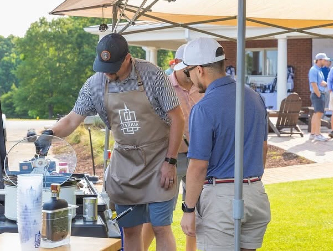 Harris team member grilling at a community cookout